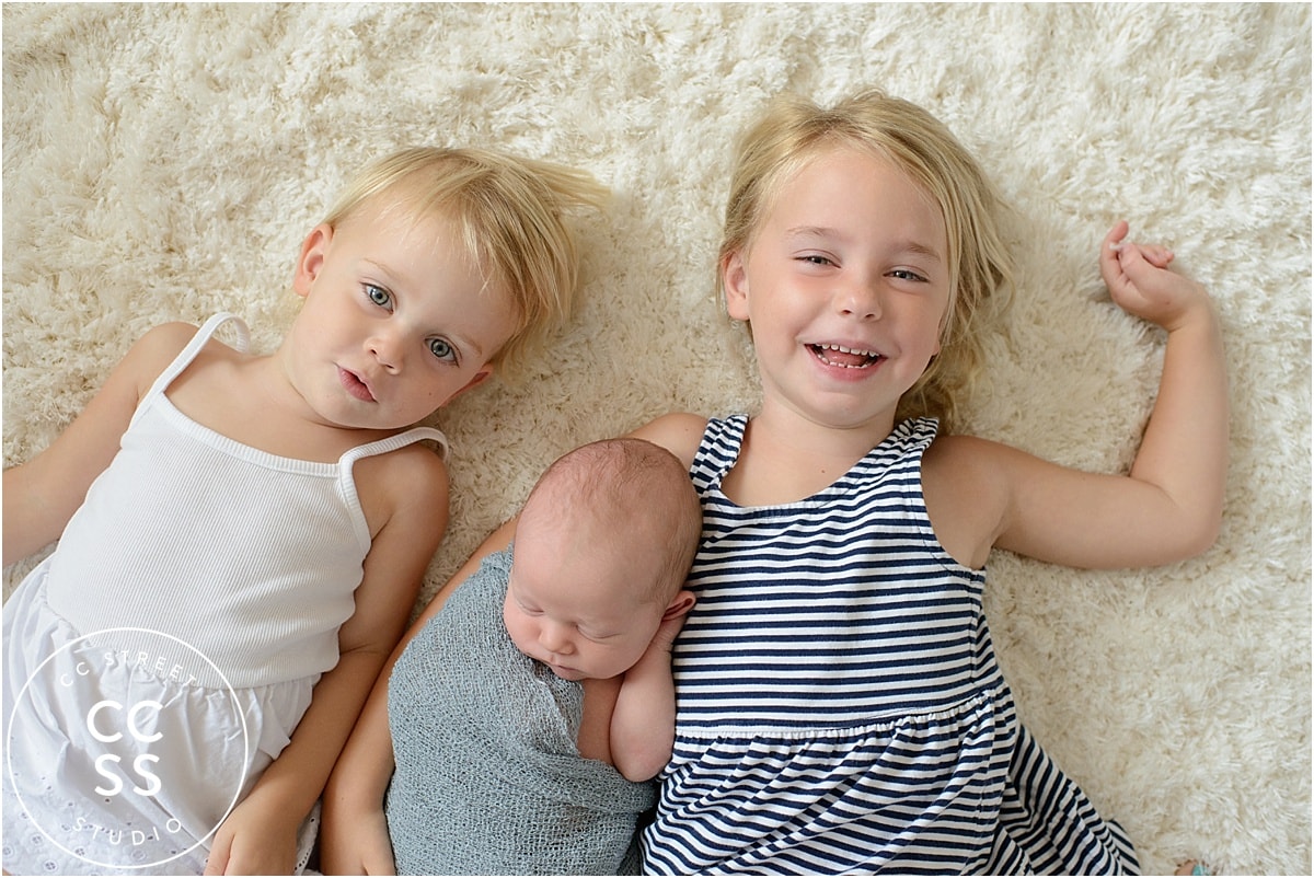 newborn baby with sisters photo